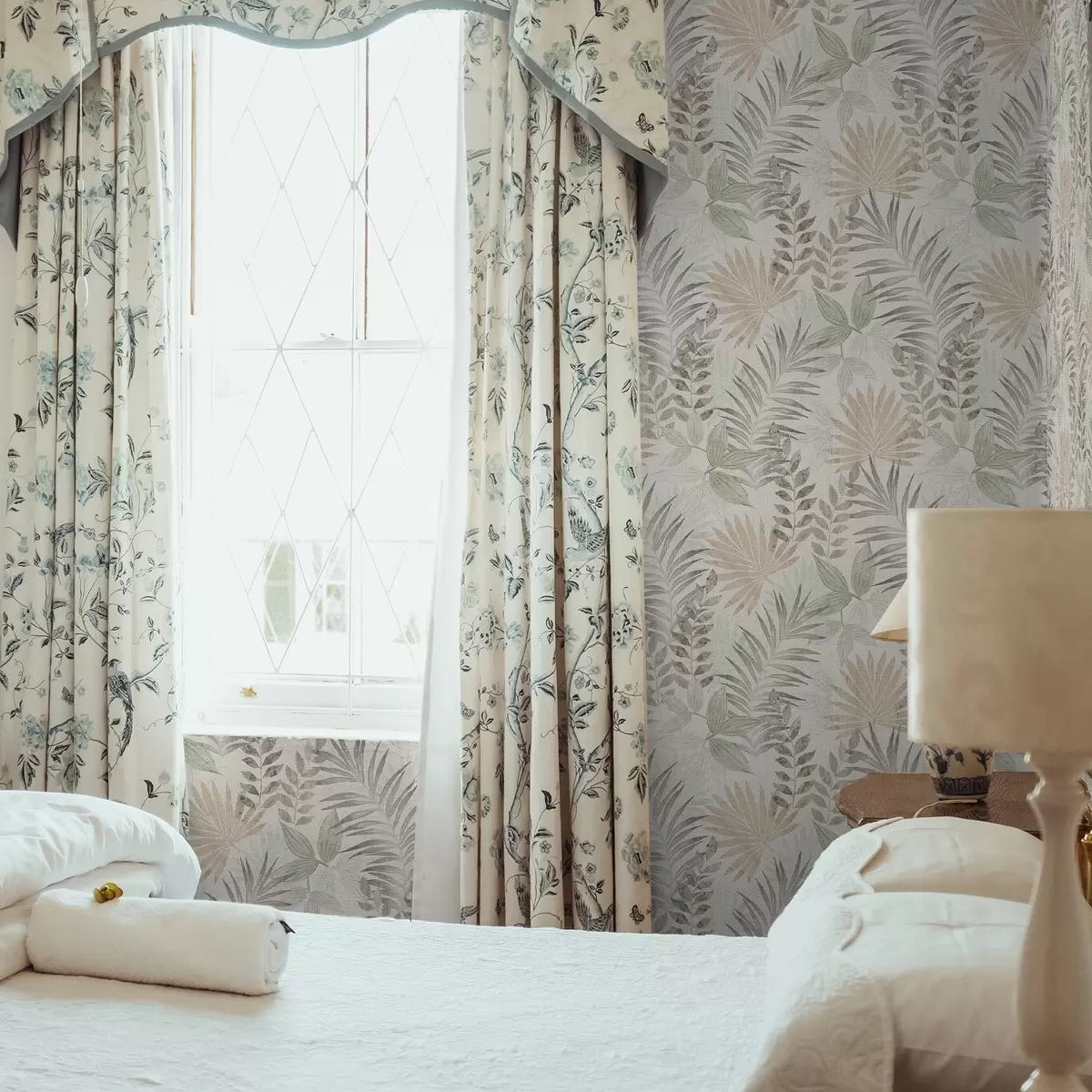 Papel pintado Hojas tropicales en tonos pastel sobre un fondo claro, textura sutil a00725