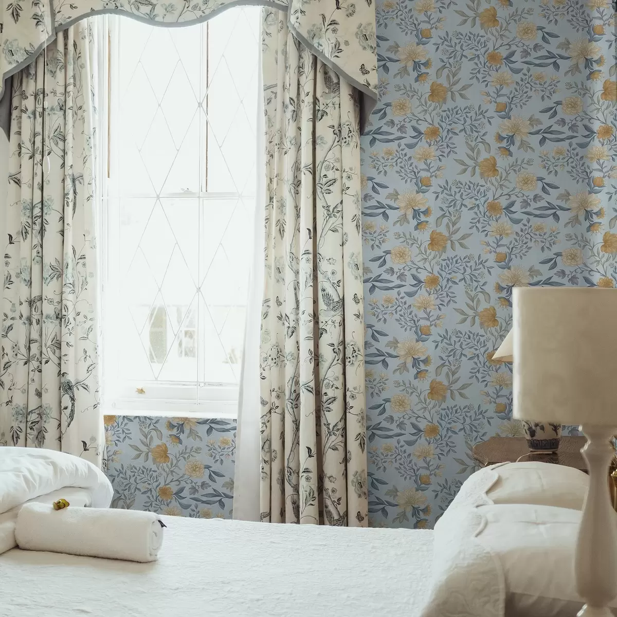 Papel pintado Flores amarillas y azules con hojas sobre un fondo azul cielo. a00934